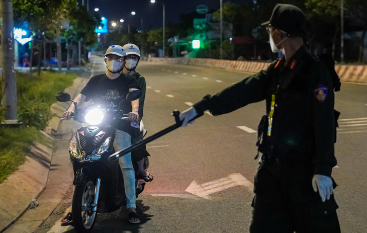 Lúc 19h, lực lượng chức năng tạm dừng đôi nam nữ đi xe máy trên đường Nguyễn Hữu Thọ. Hai người này được cảnh sát yêu cầu xuất trình giấy tờ tùy thân và khai báo lý do ra đường.