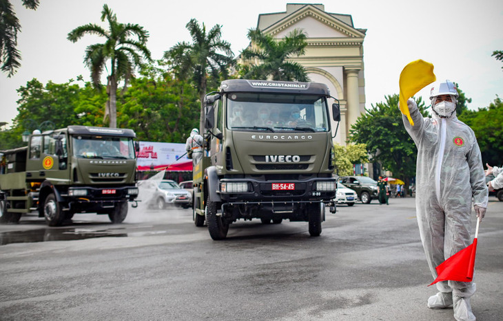 Đúng 8h, chỉ huy lực lượng quân đội ra hiệu lệnh xuất phát, đoàn xe quân đội nối đuôi nhau làm nhiệm vụ phun khử khuẩn trên nhiều tuyến phố quanh quận Hoàn Kiếm.