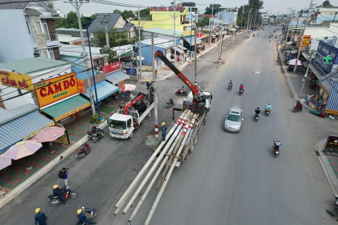 Nhân viên điện lực di dời các trụ điện cũ trên đường Đặng Thúc Vịnh, chiều 17/1
