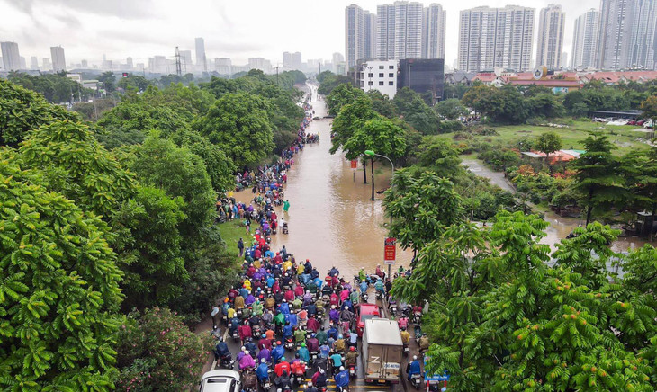 Trước biển nước, nhiều phương tiện phải dừng lại, khiến tuyến đường tắc cứng, tắc dài.