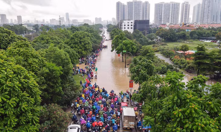 Trước biển nước, nhiều phương tiện phải dừng lại, khiến tuyến đường tắc cứng, tắc dài.