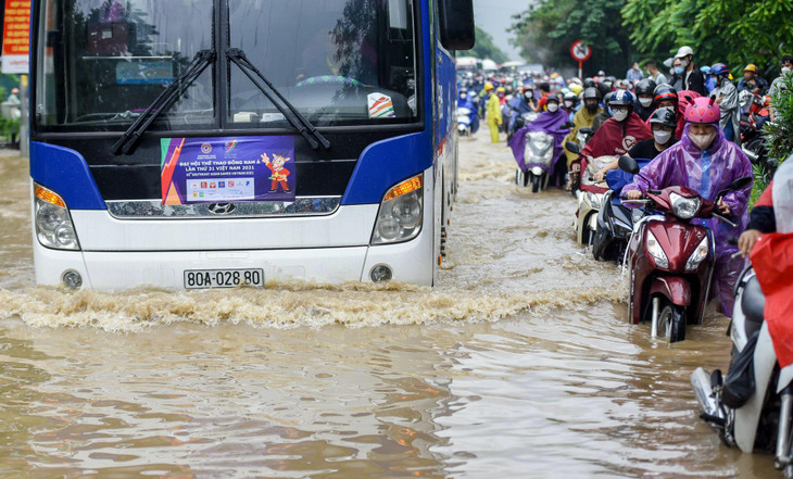 Dòng người dắt phương tiện qua cả đoạn đường ngập như sông.