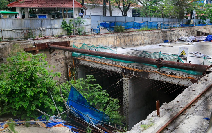 Bên trong công trường một số giàn giáo sập xuống hố, vật liệu chất thành đống, có dại mọc um tùm không có ai dọn dẹp.