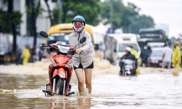 Nhiều phương tiện phải quay đầu tìm hướng đi khác. Một số người đi xe máy chọn cách dắt xe qua biển nước.