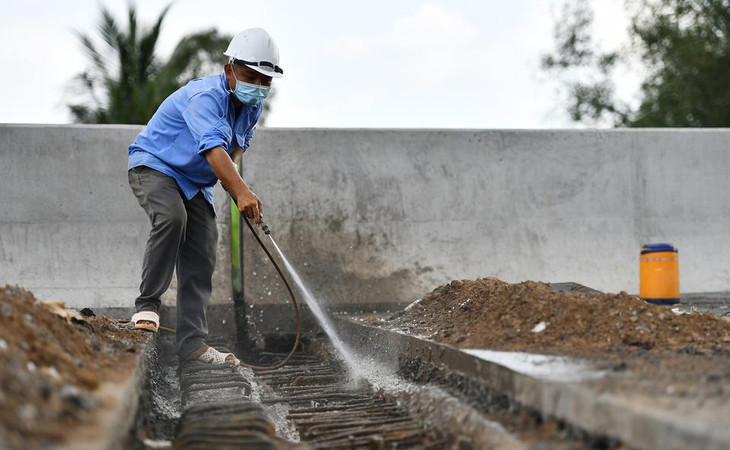 Công nhân thi công khe co giãn tại một cầu thuộc tuyến cao tốc, địa phận huyện Cái Bè. Theo chủ đầu tư, 39/39 cầu trên tuyến chính đã cơ bản hoàn thành, một số chi tiết, hạng mục phụ được thi công những ngày tới.
