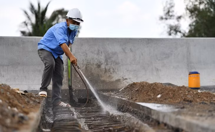 Công nhân thi công khe co giãn tại một cầu thuộc tuyến cao tốc, địa phận huyện Cái Bè. Theo chủ đầu tư, 39/39 cầu trên tuyến chính đã cơ bản hoàn thành, một số chi tiết, hạng mục phụ được thi công những ngày tới.