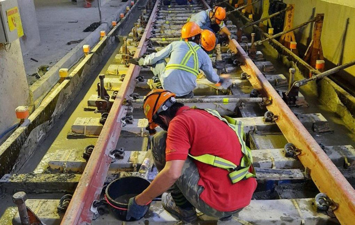 Công nhân thi công lắp đặt đoạn ray cuối cùng của Metro Số 1, ngày 9/11