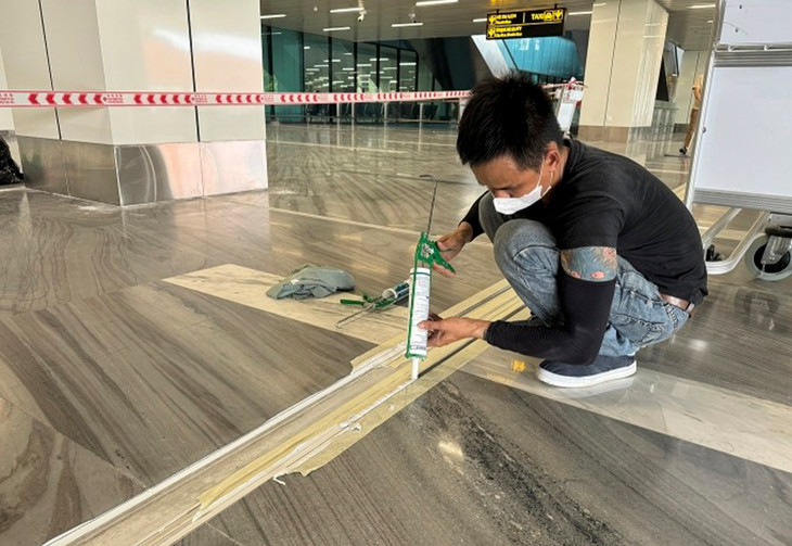 Công nhân của nhà thầu bơm keo hoàn thiện một vị trí khe co giãn trong ga T3