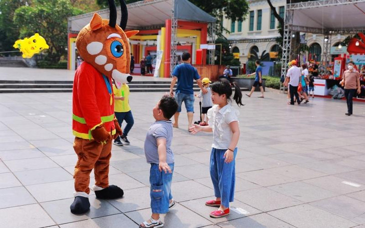 Du khách nhí tương tác với chú sao la-linh vật của SEA Games 31 tại Lễ hội quà tặng du lịch Hà Nội 2022.