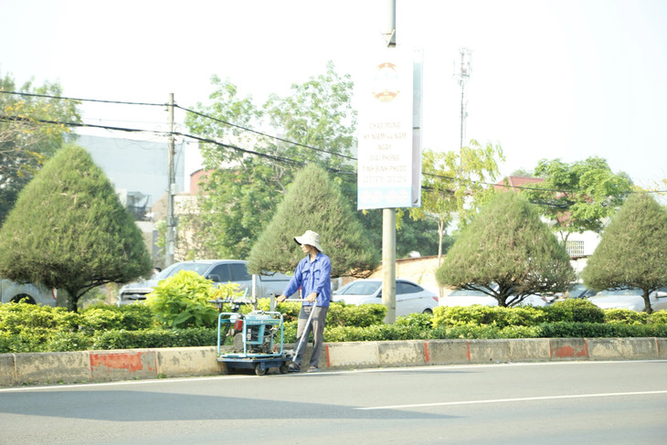 Nhân viên Công ty Công Minh đang chăm sóc cây xanh đô thị trên địa bàn tỉnh Bình Phước