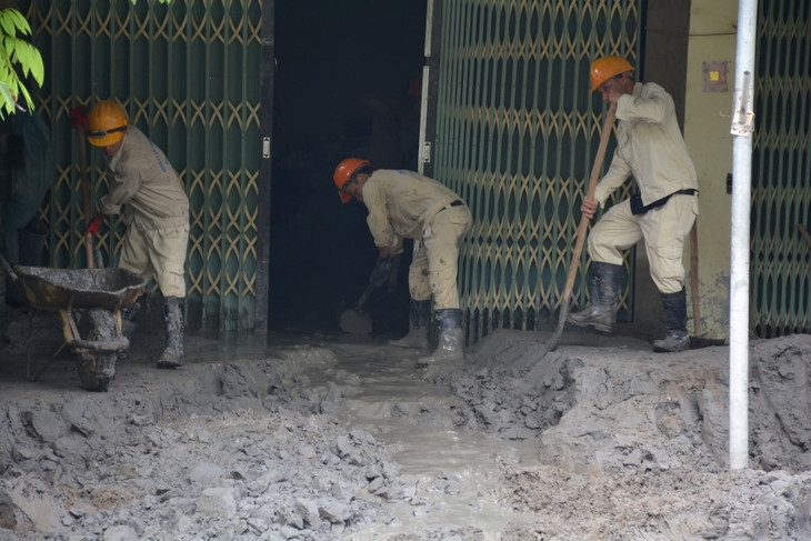 Công nhân Công ty CP Tả Phời dọn bùn thải ở nhà dân