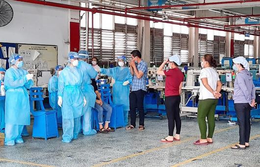 Lực lượng chức năng lấy mẫu xét nghiệm cho công nhân PouYuen