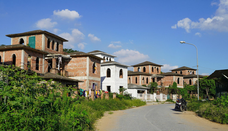 Đường vào khu biệt thự này vắng bóng người ra vào, cỏ mọc um tùm hai bên lối đi.