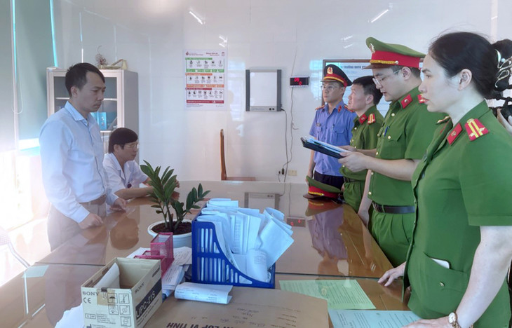 Cảnh sát đọc lệnh bắt với bác sĩ Lượng (góc trái, đứng) tại cơ quan điều tra