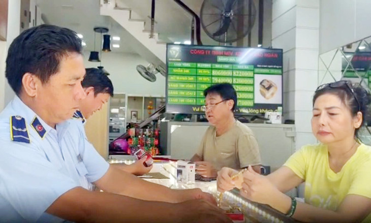 Cán bộ quản lý thị trường kiểm tra tại một cửa hàng kinh doanh vàng