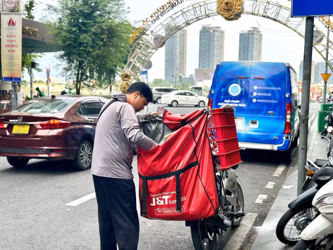 Một nhân viên giao hàng đang chờ khách trên đường Đồng Khởi, Quận 1, TP.HCM