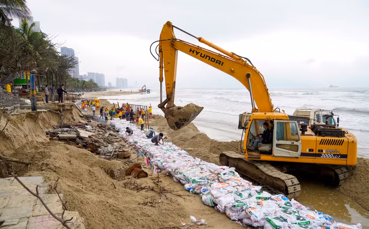 Lực lượng chức năng đã chuẩn bị hàng trăm rọ sắt để đắp đê. Công nhân phía trên liên tục vận chuyển rọ xuống khu vực sạt lở
