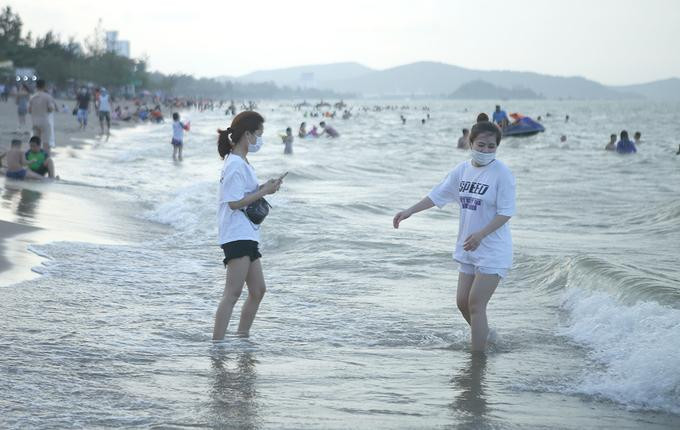 Một số khách du lịch đeo khẩu trang khi tới biển Cửa Lò