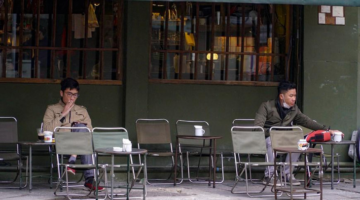 Một số người đang tận hưởng ly cà phê vào sáng đầu năm. Ảnh: Vietnam+