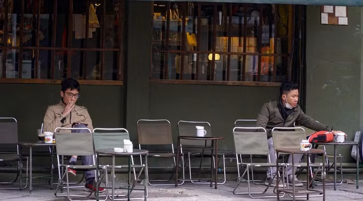 Một số người đang tận hưởng ly cà phê vào sáng đầu năm. Ảnh: Vietnam+