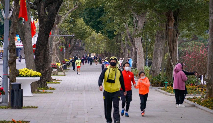 Nhiều người tranh thủ dậy sớm dạo quanh hồ Hoàn Kiếm để cảm nhận không khí tại Thủ đô Hà Nội. Ảnh: Vietnam+