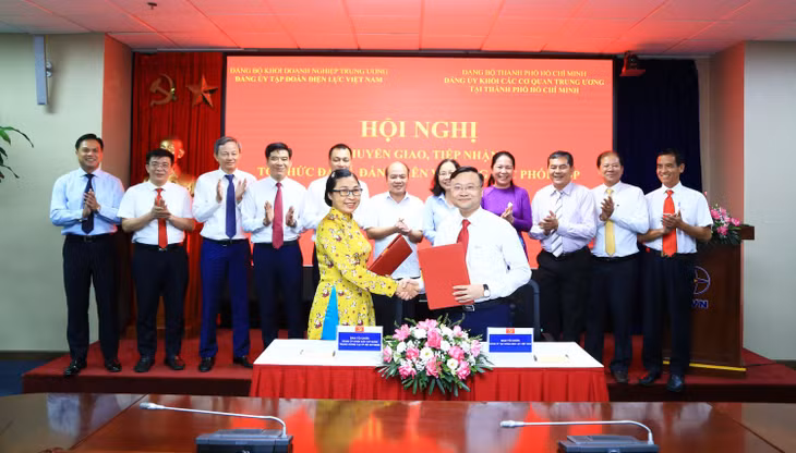 Ông Trần Việt Anh - Ủy viên Ban Thường vụ, Trưởng Ban Tổ chức Đảng ủy EVN và bà Hà Thị Hồng Hải - Ủy viên Ban Thường vụ, Trưởng Ban Tổ chức Đảng ủy Khối các cơ quan Trung ương tại thành phố Hồ Chí Minh ký kết Biên bản bàn giao hồ sơ đảng viên. Ảnh: Anh Tuấn