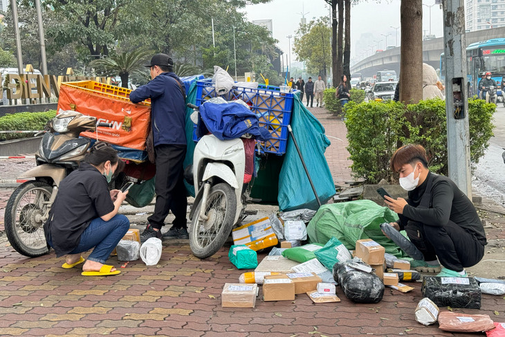 Shipper chờ khách nhận hàng tại phố Duy Tân, Cầu Giấy, Hà Nội