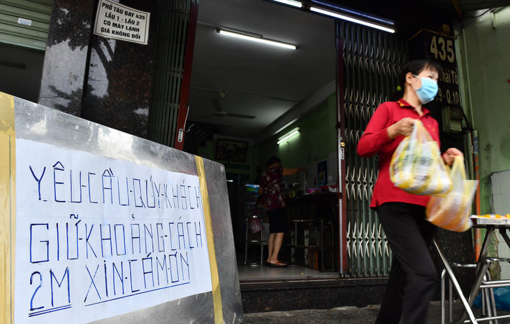Nhân viên một cửa hàng thức ăn nhanh ở Quận 10 khá tật bật. Khách đến đây được yêu cầu không đứng gần nhau.