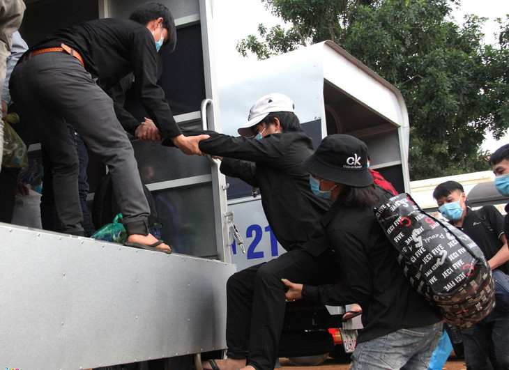 Anh Thầu A Mà (23 tuổi, quê Hà Giang) bị thương ở chân, được bạn hỗ trợ đưa lên xe. "Thất nghiệp hơn 3 tháng nên tôi quyết định đi bộ về quê với nhóm bạn. Tôi bị thương ở chân nên đi bộ rất khó khăn, mày mà được chính quyền hỗ trợ", A Mà nói.