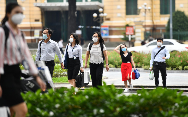 Trước cổng Bưu điện TP.HCM (Quận 1), nhóm nhân viên của một công ty bất động sản khẩn trương đi làm ngày đầu tuần.