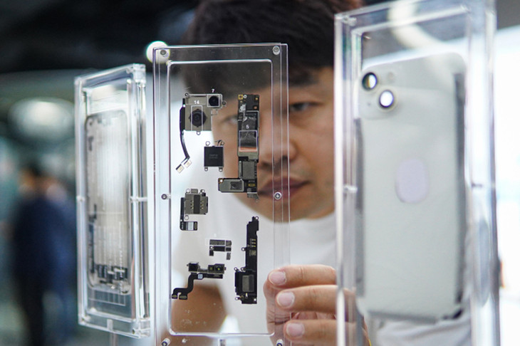 Một khách tham quan đang nhìn vào các thành phần của chiếc iPhone sử dụng keo dán 3M được trưng bày tại Trung tâm Khoa học Công nghệ và Kỹ thuật tại Hà Nội