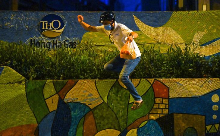 Một người đàn ông nhận gói hàng từ trong khu vực phong tỏa chưa qua khử khuẩn nhanh chóng rời đi.