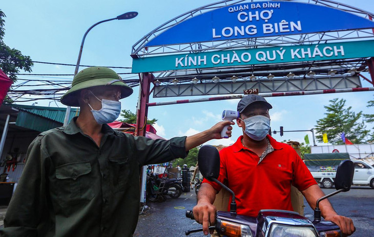 Người dân ra vào chợ phải kiểm tra thân nhiệt và sát khuẩn tay ngay tại lối vào chính.