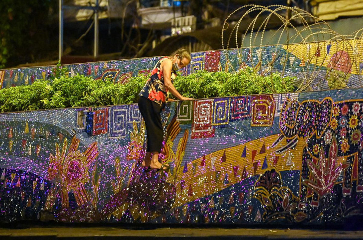 Người phụ nữ cao tuổi không quản ngại nguy hiểm trèo qua bức tường đê cao hơn 2 m để ra ngoài.