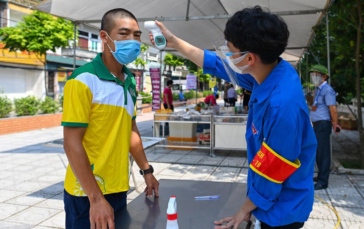 Người dân đến mua hàng tại siêu thị lưu động được đo thân nhiệt, xuất trình thẻ đi chợ do cơ quan chức năng cấp.