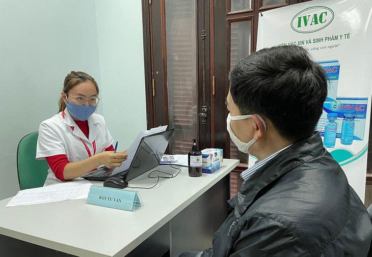 Đại diện nhóm nghiên cứu (trái) tư vấn cho người đăng ký tham gia thử nghiệm vaccine, tại Trường Đại học Y Hà Nội