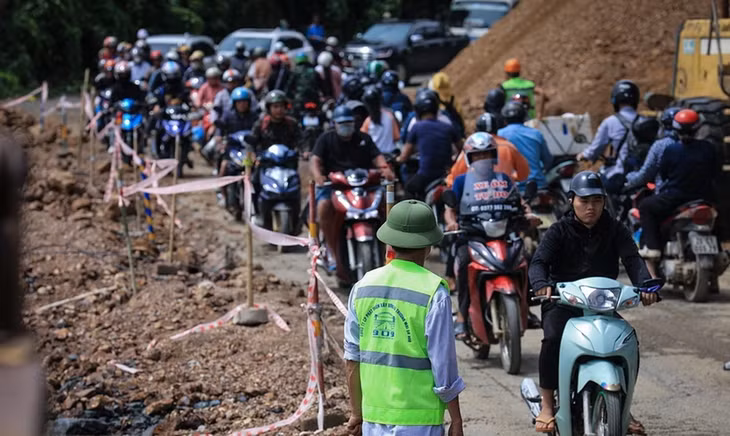 Người và phương tiện giao thông di chuyển chậm nối nhau đi qua điểm sạt lở tại dốc Cun, Km79+335, Quốc lộ 6, thuộc địa phận phường Thống Nhất, thành phố Hòa Bình