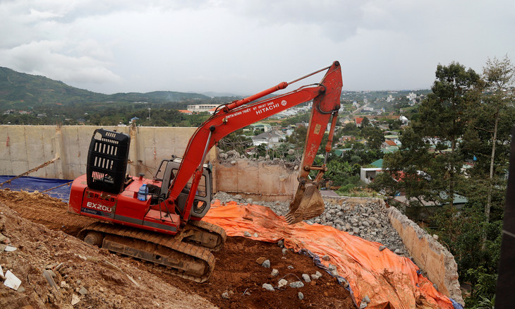 Xe múc tiến hành tháo dỡ taluy bằng bêtông