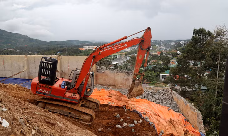 Xe múc tiến hành tháo dỡ taluy bằng bêtông