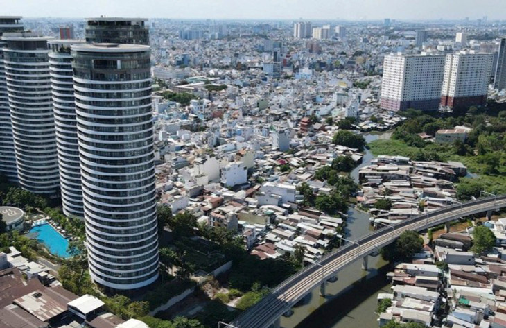 Dãy nhà lụp xụp ven rạch Văn Thánh, quận Bình Thạnh, kế bên là các cao ốc và đoạn trên cao Metro Bến Thành - Suối Tiên chạy qua