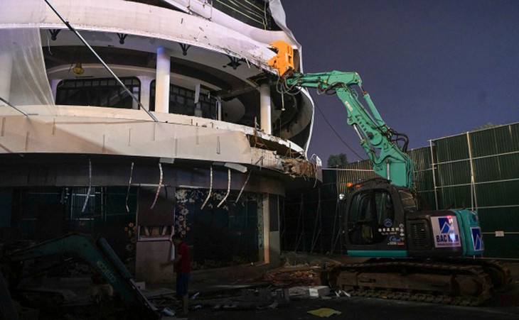 Máy xúc bắt đầu phá dỡ sàn bêtông tòa nhà khuya 19/6