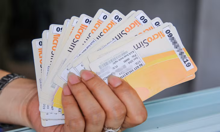 Một tệp thẻ sim trên tay người bán tại một cửa hàng ở Hà Nội