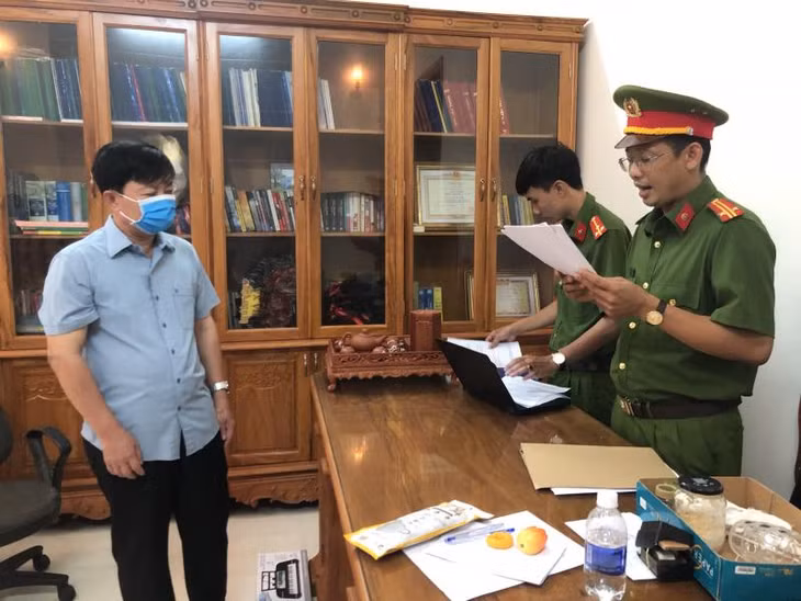 Cơ quan CSĐT Công an tống đạt quyết định khởi tố và khám xét nơi làm việc của ông Đăng. Ảnh: CAND