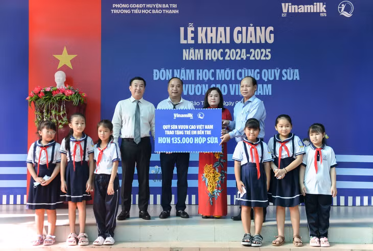 Đại diện Vinamilk &amp; Quỹ bảo trợ trẻ em Việt Nam (bên trái) trao bảng tượng trưng phần hỗ trợ hơn 135.000 hộp sữa cho đại diện Sở Lao động thương binh &amp; xã hội tỉnh Bến Tre nhân ngày khai giảng 5/9