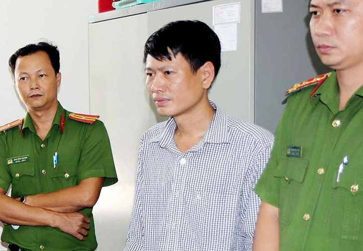 Bị can Lê Thành Bắc (giữa) nghe đọc lệnh bắt, sáng 30/6. Ảnh: Văn Trăm