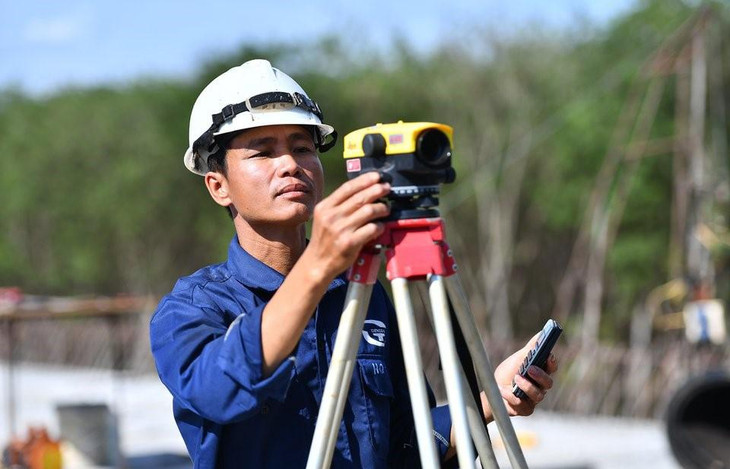 Anh Quyết, nhân viên kỹ thuật, đang kiểm tra cao độ cầu vượt quốc lộ 56 thuộc địa bàn thành phố Long Khánh. Sau đó, công nhân sẽ đổ bê tông mặt cầu đoạn đường này.