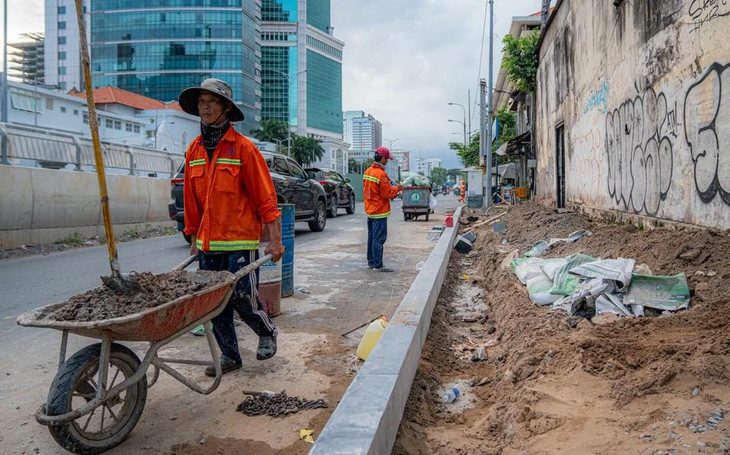 Phía bên phải cầu, mặt đường Tôn Đức Thắng hướng về quận 1, công nhân đang thi công lát gạch nền, tái lập hoàn trả hiện trạng tuyến đường. Phía bên phải cầu, mặt đường Tôn Đức Thắng hướng về quận 1, công nhân đang thi công lát gạch nền, tái lập hoàn trả hiện trạng tuyến đường.
