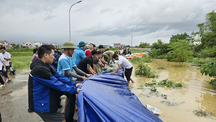 Người dân và các lực lượng chức năng chung tay gia cố đê bối Đầu Hàn, khu vực phường Hòa Long, thành phố Bắc Ninh, khi nước sông Cầu dâng cao