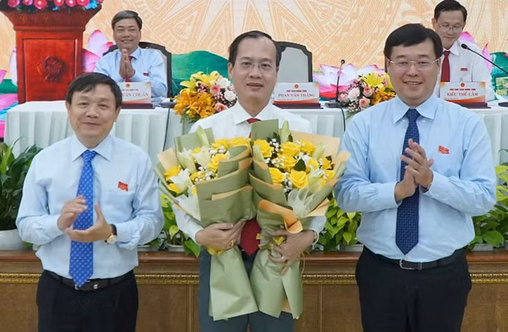 Ông Trần Trí Quang (giữa) nhận hoa chúc mừng từ lãnh đạo Tỉnh ủy Đồng Tháp