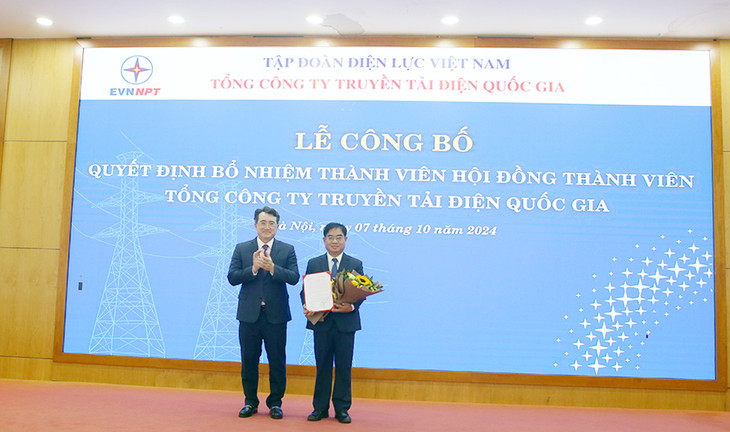 Ông Đặng Huy Cường - Ủy viên BTV Đảng ủy, Thành viên HĐTV EVN trao Quyết định và tặng hoa chúc mừng ông Đỗ Đức Hùng